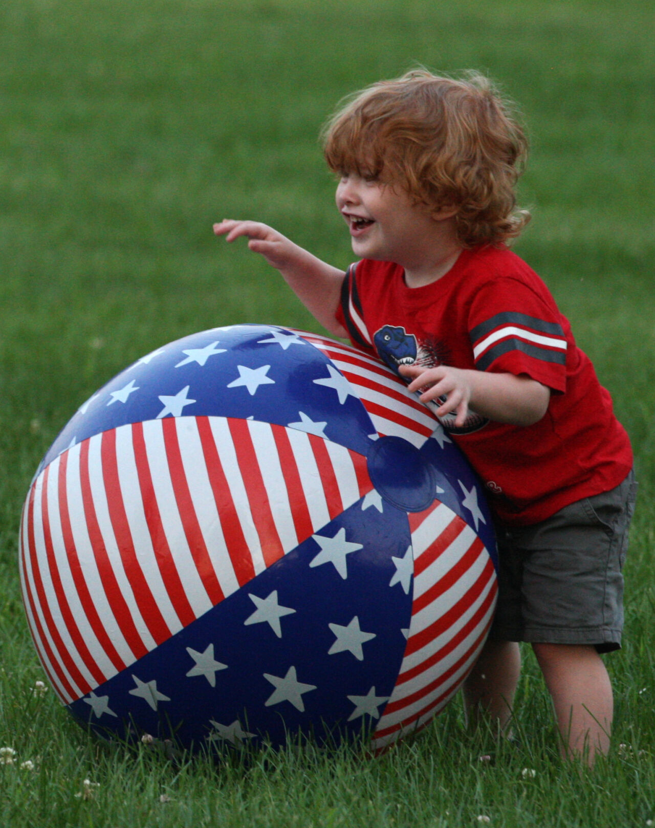 Oliver Cummins plays with a beach ball